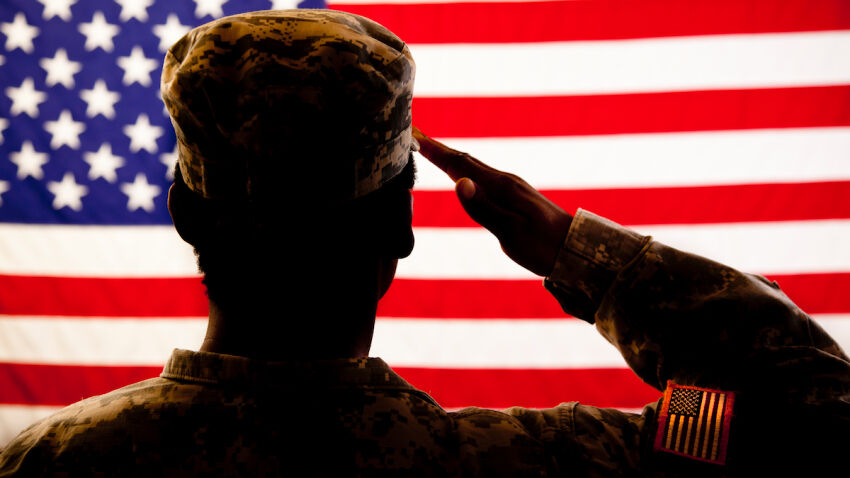 Silhouette of soldier saluting the American flag